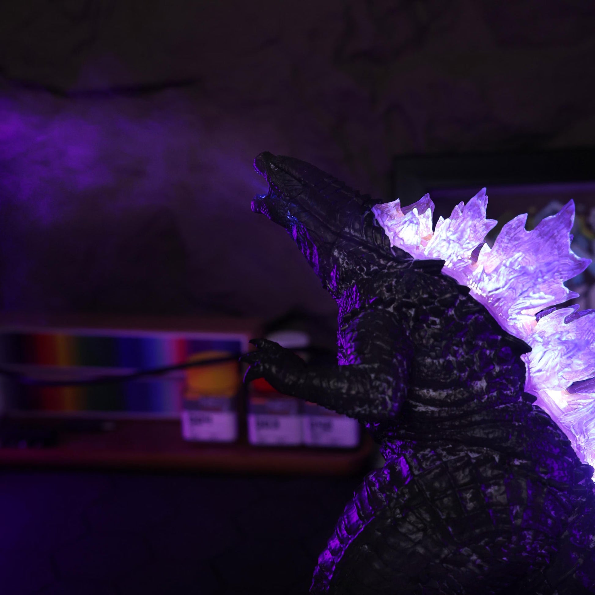 Full Mistzilla figure lit in dramatic red and blue light